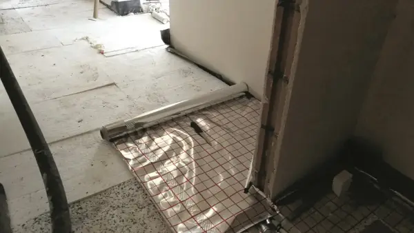 Podłoga garażowa w trakcie budowy z folią izolacyjną i siatką zbrojeniową.